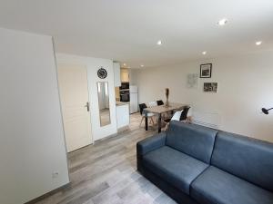 a living room with a blue couch and a table at 6 personnes / Proche Disney et aéroport CDG in Annet-sur-Marne +21 photos