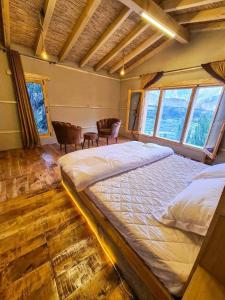 um quarto com uma cama grande num quarto com janelas em Kungrah Resort em Chamangul