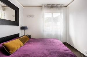 Un dormitorio con una gran cama púrpura con espejo en Carpe Diem, en Beaulieu-sur-Mer