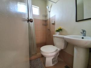 a bathroom with a toilet and a sink and a shower at Casa De Mira in Angeles