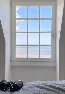 een slaapkamer met een raam met uitzicht op de oceaan bij Magnifique cocon vue mer in Trouville-sur-Mer