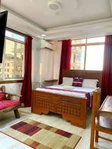 a bedroom with a large bed with red curtains at Amazing Apartment Free Parking & Security in Dar es Salaam