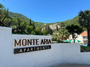 a sign for monte arkin apartments on a wall at Monte Aria panorama suites in Herceg-Novi