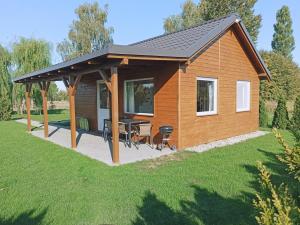 a pavilion with a table and chairs in a yard at Pod Wierzbami in Żuławki