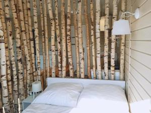 a bedroom with a wall of tree trunks at Pod Wierzbami in Żuławki