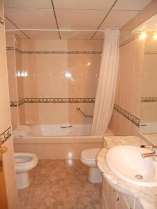 a bathroom with a tub and a toilet and a sink at Apartamentos Palas Salou in Salou
