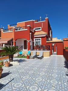 - un bâtiment rouge avec une terrasse en face dans l'établissement Casa Azul, à Alicante