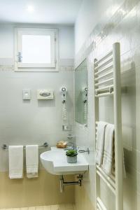 Baño blanco con lavabo y espejo en Hotel Euro, en Bellaria-Igea Marina