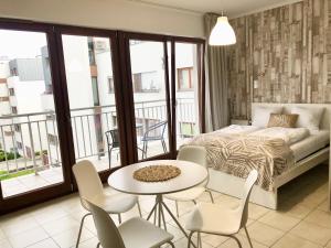 sypialnia z łóżkiem, stołem i krzesłami w obiekcie Apartamenty Platan - visitopl w Świnoujściu +36 zdjęć
