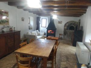a living room with a wooden table and a fireplace at Mas du Roy in Sénéchas
