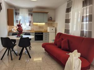 a living room with a red couch and a table at Apartments Celebrini in Malinska
