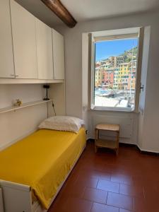 a bedroom with a yellow bed and a window at Sori Mare in Sori