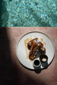 un plato de comida en una mesa junto a una piscina en Harding Boutique Hotel, en Ahangama
