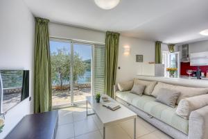 - un salon avec un canapé et une table dans l'établissement Portalbona Apartments - Apartment 6, à Rabac