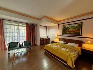 una camera da letto con un letto, un tavolo e delle sedie di Cool Point Hotel a Tanah Rata