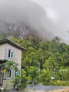 une maison en face d'une colline avec une montagne dans l'établissement บ้านเล็กในป่าใหญ่โฮมสเตย์ กงหรา พัทลุง, 