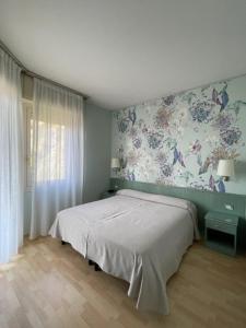 a bedroom with a bed and a floral wall at Sole Mare in Ventimiglia