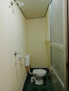 a small bathroom with a toilet and a shower at Goroomgo Rainbow Residency Varanasi Near By Assi Ghat River - Excellent Service in Varanasi