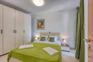 - une chambre avec un lit vert et 2 oreillers dans l'établissement Portalbona Apartments - Apartment 6, à Rabac