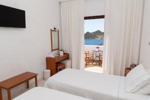 a hotel room with two beds and a view of the ocean at Golden Sun Hotel Patmos in Patmos