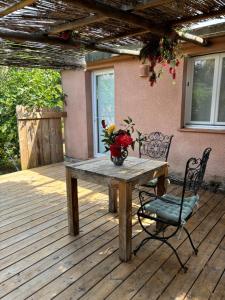 a wooden table with a vase of flowers on a deck at La vie en rose in Coti-Chiavari