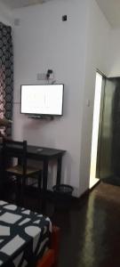 EESTEE Canal في كولومبو: غرفة مع طاولة وتلفزيون على الحائط