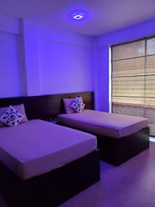 a purple room with two beds and a window at Royal Restaurant in Warakapola