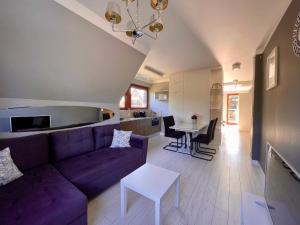 a living room with a purple couch and a table at Apartamenty-Baltivia in Hel