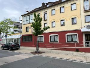 a small tree in front of a building at Hotel-Restaurant Zum Kirschbaum in Rottendorf