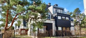 a black and white house with a fence at Apartamenty-Baltivia in Hel