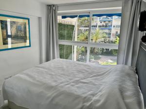 1 dormitorio con cama y ventana grande en Skol Apartments Marbella, en Marbella