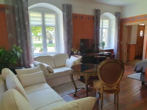 - un salon avec un canapé et une table dans l'établissement Gesindehaus am Schloss Kummerower See, à Kummerow