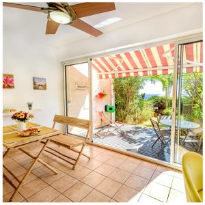 a living room with a sliding glass door to a patio at Le jardin des Tuit Tuit * Vue Mer * Cozy in Saint-Leu
