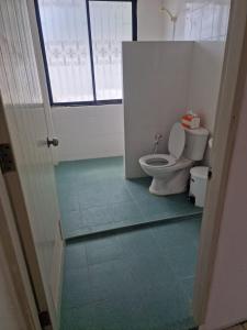 a bathroom with a toilet and a window at Paradise Bar & Guesthouse in Pattaya South