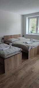 two twin beds in a room with a window at Apartmán Orchidea in Stará Ľubovňa