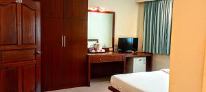 a bedroom with a bed and a desk with a television at Sea Star House in Ao Nang Beach
