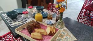 einen Tisch mit einer Schachtel Brot und Orangensaft in der Unterkunft Moulin de Parayre in Les Vignes