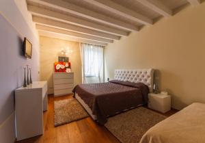 een slaapkamer met een bed, een dressoir en een raam bij Vip Bergamo Apartments in Bergamo