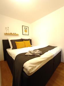 1 dormitorio con 1 cama grande con almohadas amarillas en Altdorf entdecken: Stadtnähe NBG en Altdorf bei Nuernberg