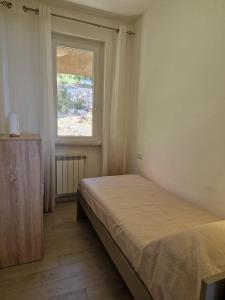 a bedroom with a bed and a window at La finestra sul golfo in Ospedaletti