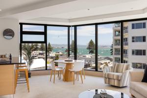 a living room with a view of a building at Luxury Ocean & Harbour Views - Heated Pool, Main Beach & Gym in Mount Maunganui