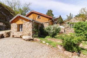 una pequeña casa de piedra con un banco delante en Chalet en Castel, en Ax-les-Thermes