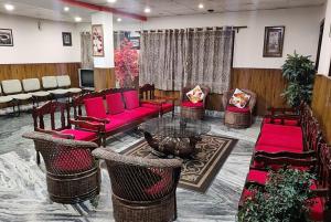 a waiting room with red furniture and a table and chairs at Hotel Kasturi Palace Darjeeling - Excellent Service Recommended in Darjeeling