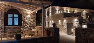 um edifício de pedra com luzes acesas à noite em Sophia Town Square Areopoli em Areopoli