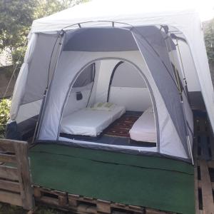 a tent with a bed inside of it at Deux tentes confortables dans un joli jardin idéalement situé in Sète