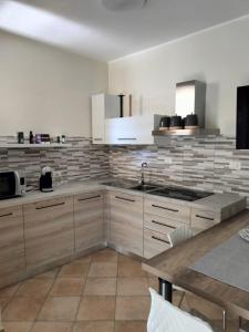 a kitchen with white cabinets and a sink and a table at La Caletta di Dany in Castelsardo