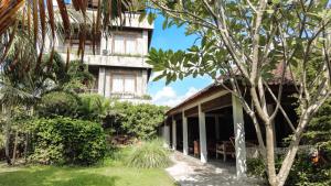an exterior view of a building with trees at Ohmmstay - Rumah Pendopo in Tanjungtirto