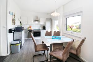eine Küche mit Tisch und Stühlen und einem Fenster in der Unterkunft Ferienhaus Achterwasser in Lütow