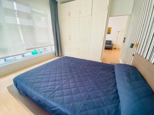 a large blue bed in a room with a large window at central apartment in Santurce