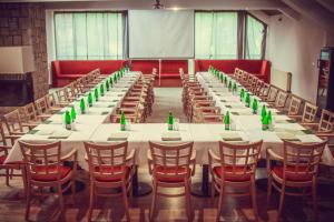 ein großer Konferenzraum mit langen Tischen und Stühlen in der Unterkunft Hotel Esprit in Špindlerův Mlýn